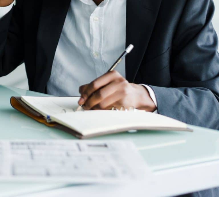 person writing in notebook